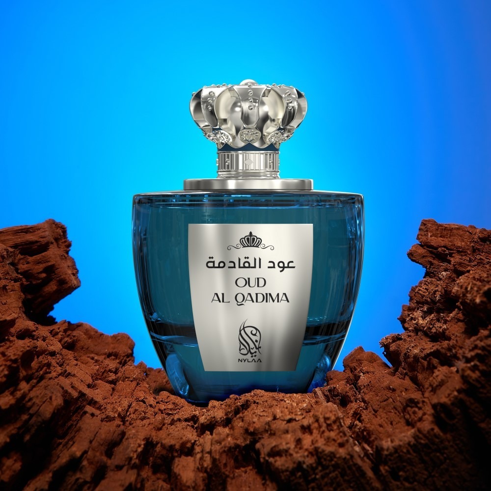 A blue perfume bottle with a silver cap from Nylaa by Savia Exclusive against a blue background