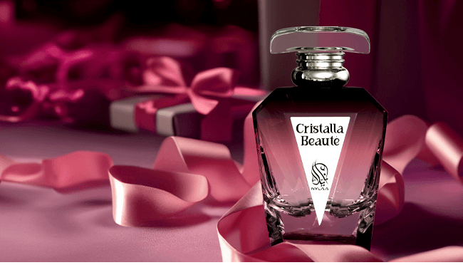 A maroon perfume bottle by Savia Exclusive with maroon ribbons & gift boxes in the background