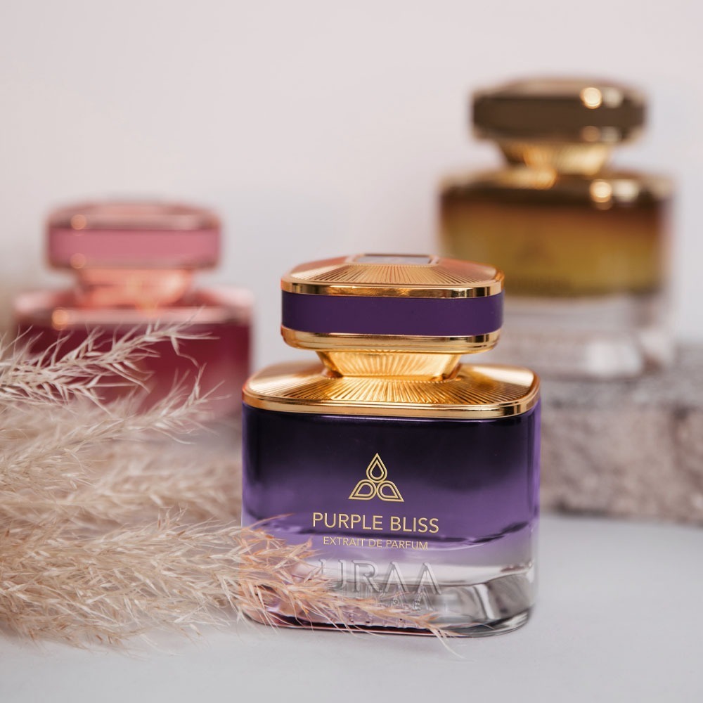 A purple perfume bottle by Savia Exclusive with feathers