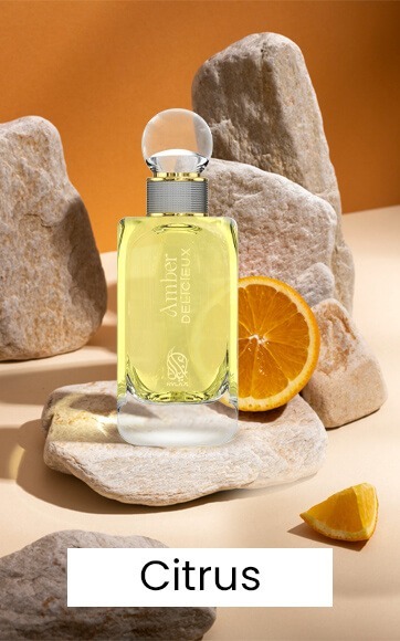 A yellow perfume bottle by Savia Exclusive with rocks & orange slices